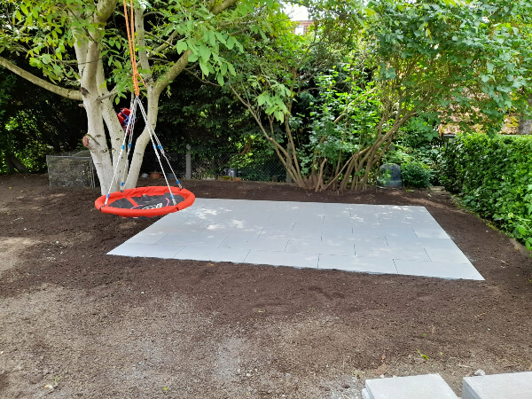 Sitzplatz aus Betonplatten unter Baum